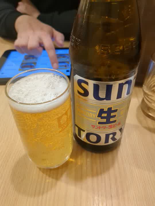 Ein Glass japanisches Bier nehem seiner Flasche.